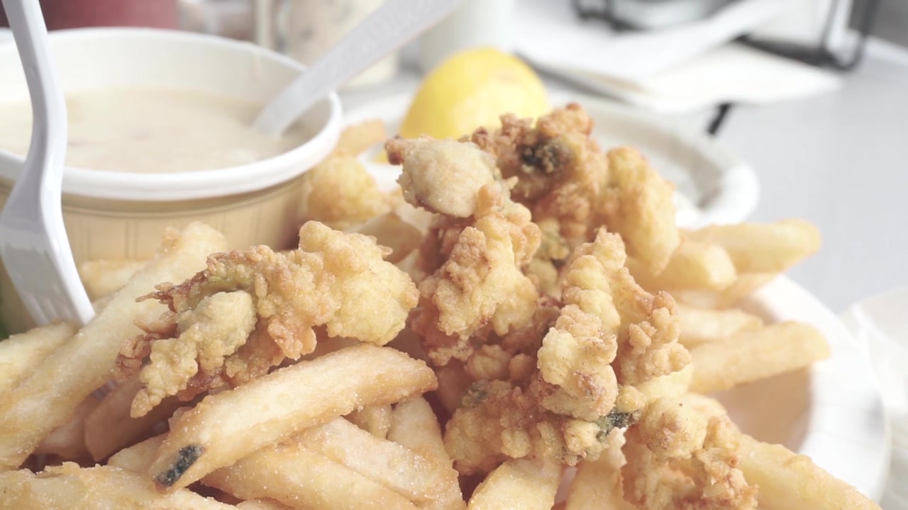 Tasty closeup of fried clams and french fries in Portland, Maine.