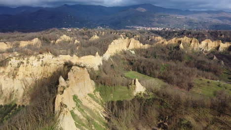 aerial flying drone panning shot over prehistoric age canyons le balze natural reserve near reggello. tuscany, chianti area. italy. winter season, partially sunny sunset.