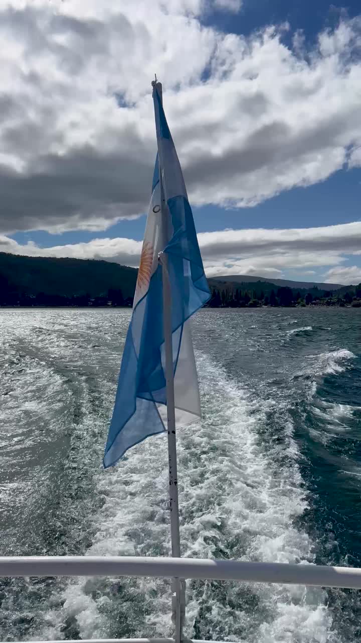 A boat flag waving in Patagonia with a scenic view of the water and sky behind