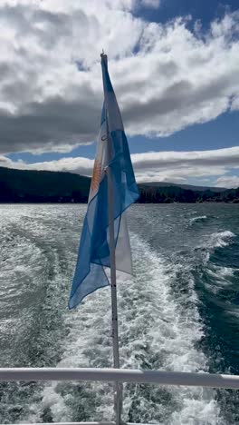 a boat flag waving in patagonia with a scenic view of the water and sky behind