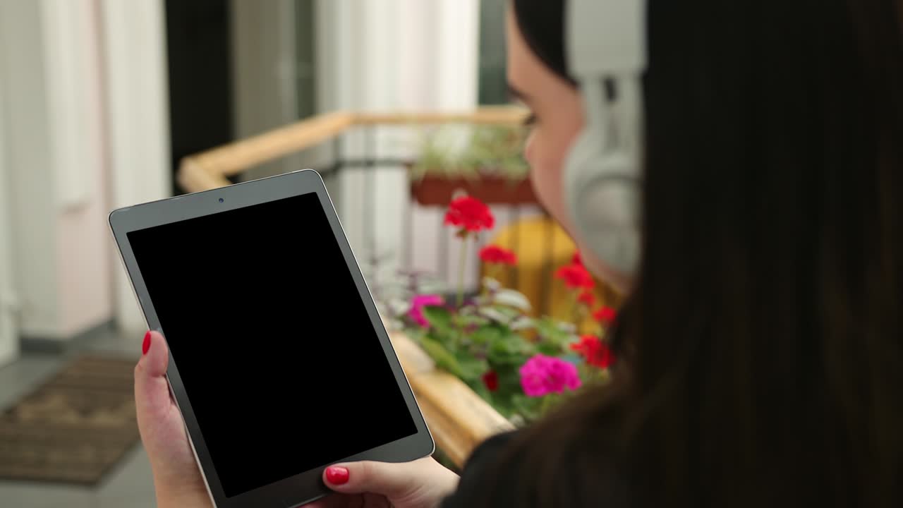 카페에서 여성 사업은 태블릿 비디오 통화로 작동합니다. 밖에서 일하는 모바일