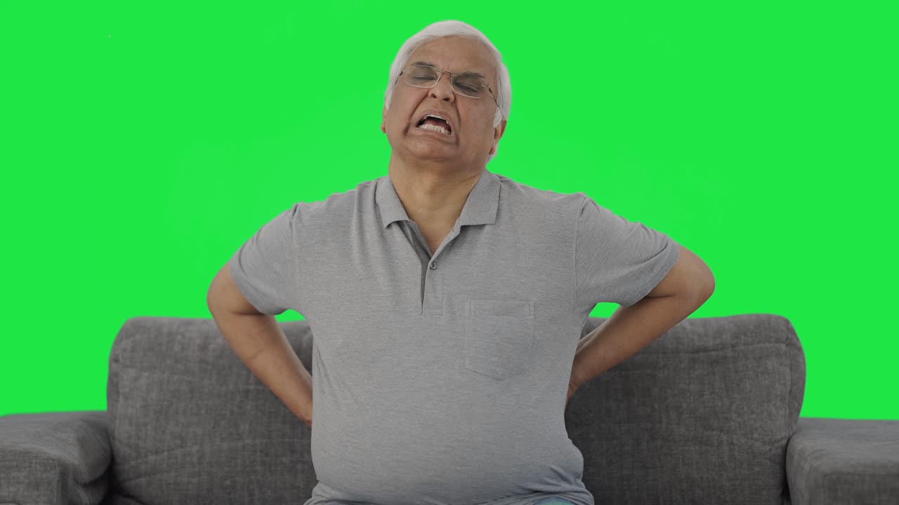 Sick Indian old man suffering from back pain Green screen