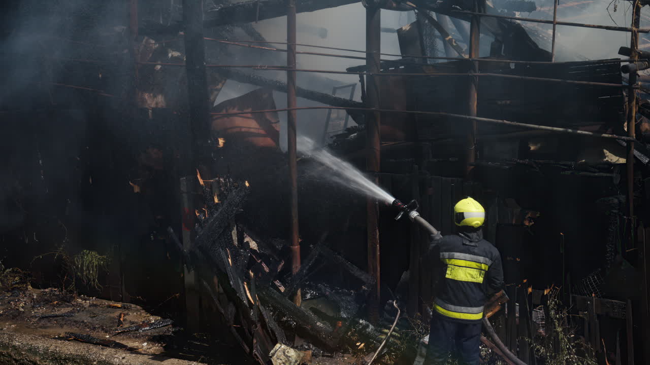 Pompiere che cerca di spegnere un incendio in una casa