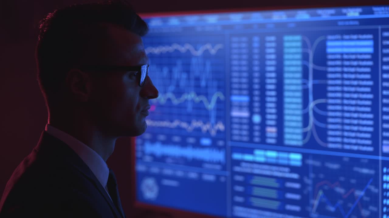 The businessman looks on blue monitors in a lab