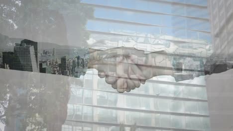 Mid-section-of-businessman-and-businesswoman-shaking-hands-against-tall-buildings-in-background