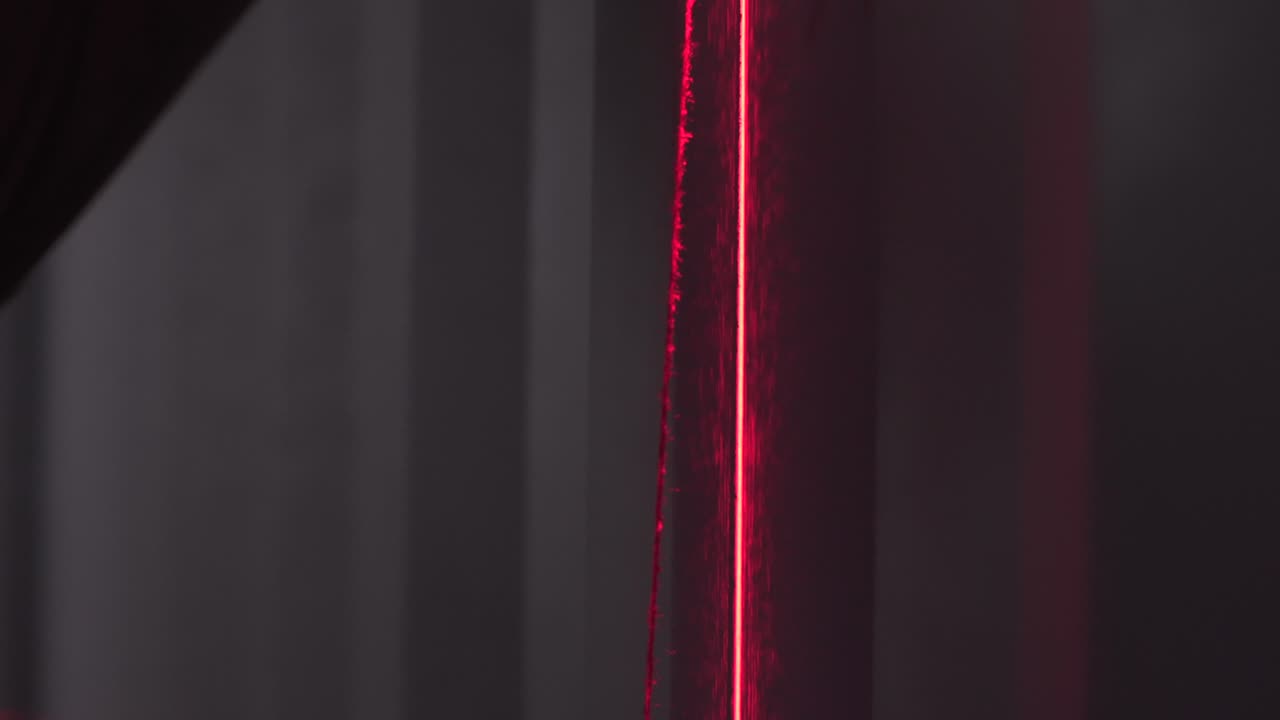 красная лазерная линия на стене с шторами