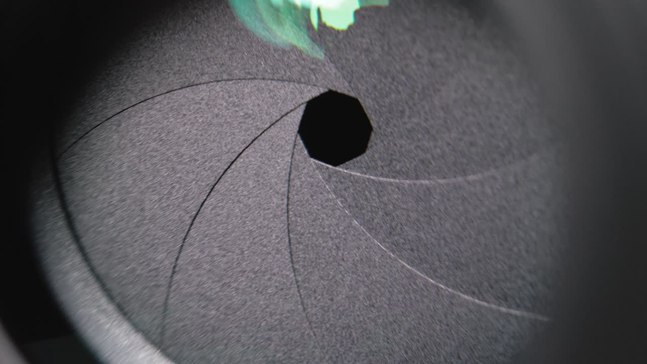 Camera lens aperture close-up. Aperture blades opening and closing during shooting