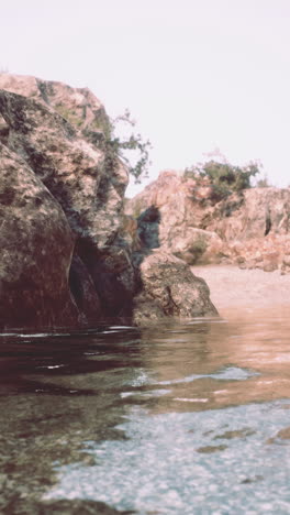 a serene landscape with a creek running through it, surrounded by rocky hills