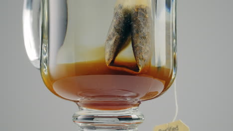 fresh teabag in a glass of hot water - close up on a turntable