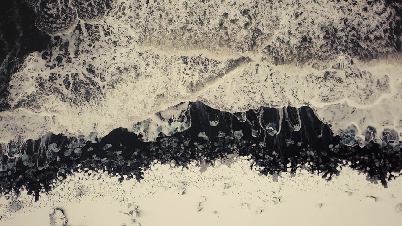 кинематографические движения дрона показывают пляж с черным песком в исландии, снятый дроном в снежных условиях