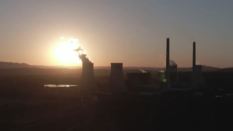 aerial: drone circling a power plant station during sunset in new south wales, australia