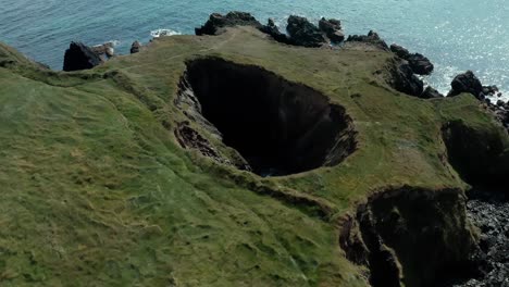 birds eye wide angle view of small hole in cliff near seaside coast