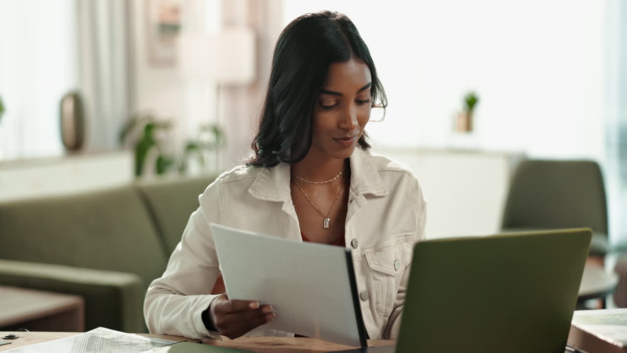 Woman working from home with laptop and documents