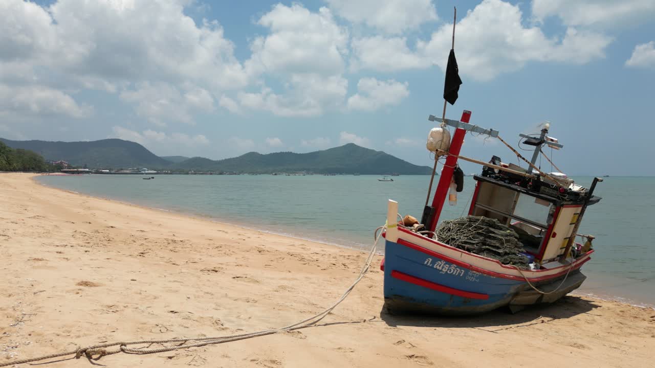 un colorido barco de pesca de madera en la playa de tailandia