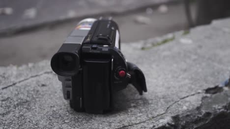 a forgotten camcorder on a concrete fence