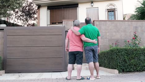 two friends embracing in front of a house