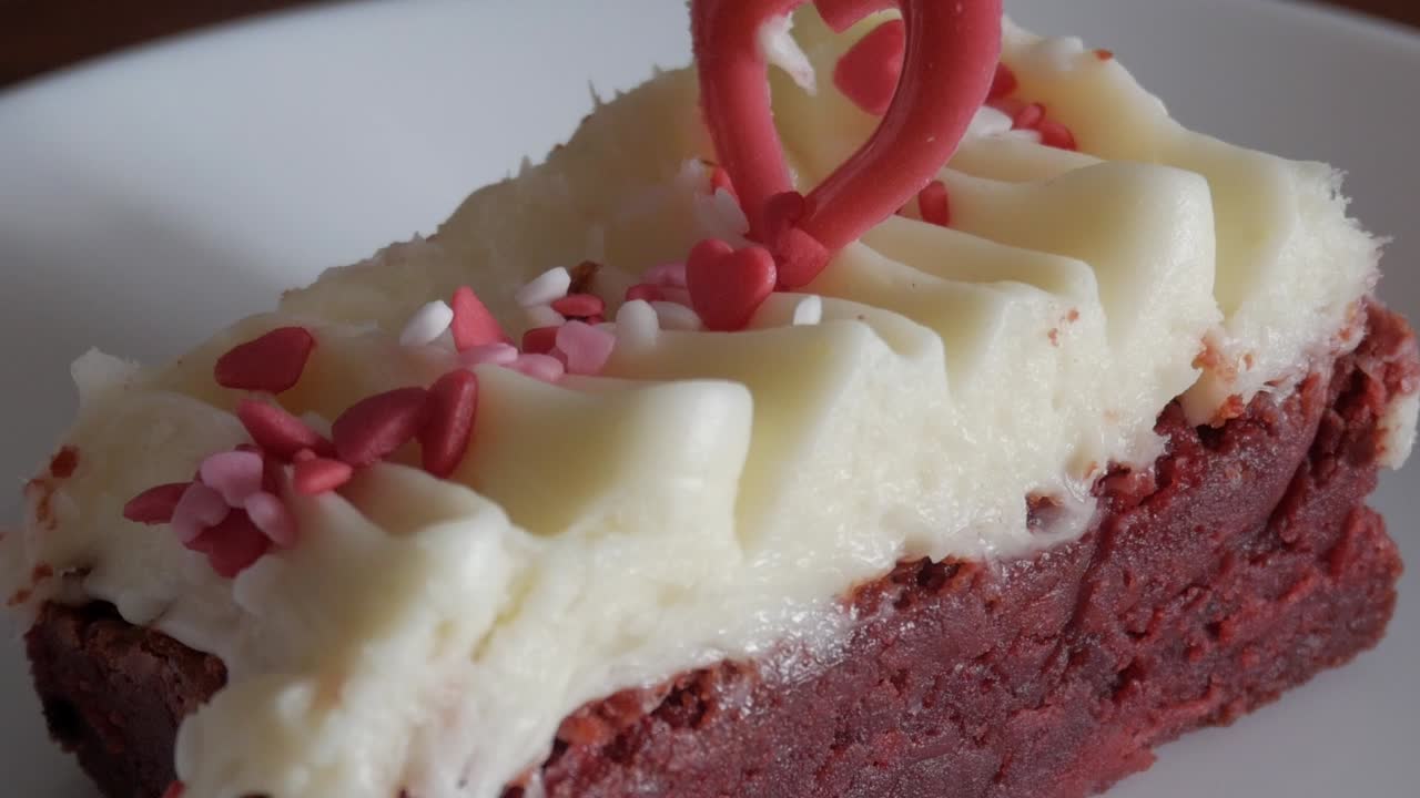 Red velvet brownie with cream cheese frosting, heart sprinkles, Valentine's mood