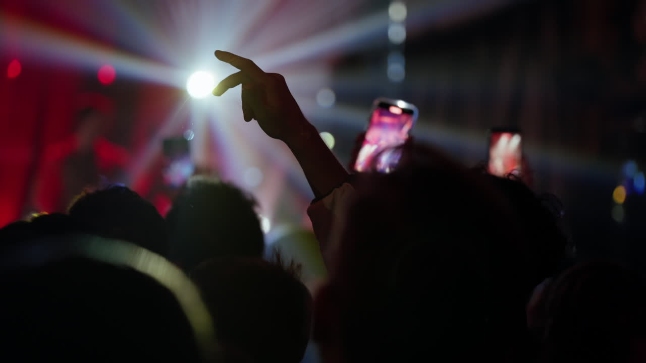 Folla energica a un concerto di musica dal vivo che riprende con smartphone