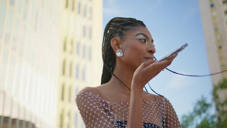 trendy woman talking phone loudspeaker at street closeup. lady recording message