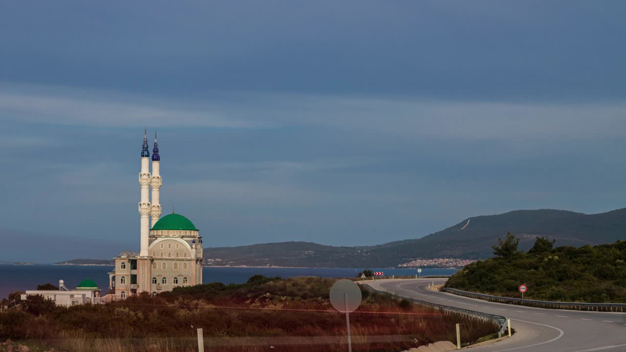 tráfico, time-lapse, mezquita y minaretes cerca de la carretera y el mar en la ciudad turca de izmir