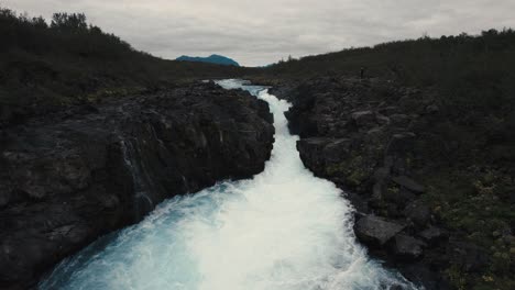 aerial clear blue waterfall river hlauptungufoss iceland, flying over foaming waves