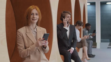 portrait of red-haired caucasian businesswoman using mobile phone