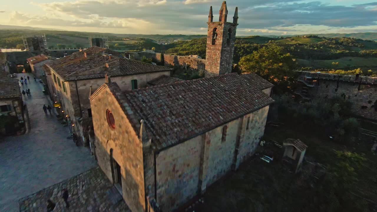 vuelo rápido sobre la comuna de monteriggioni al atardecer, provincia de siena, italia