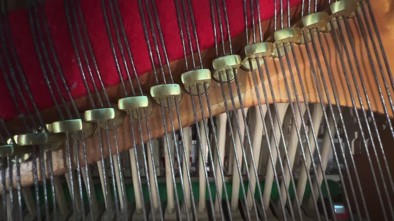 Close-up of piano hammers and strings in action. Detailed view of the intricate internal mechanism of a classical upright piano as it's being played. Sound and music concept