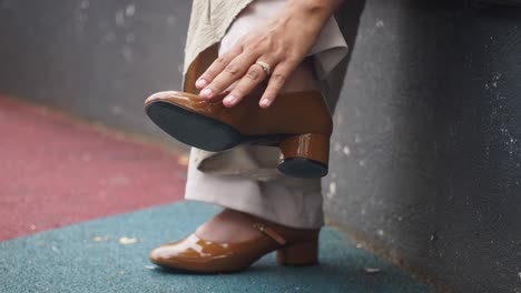 woman putting on brown high heels