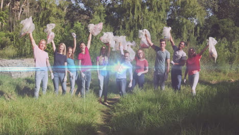 video of lights over cheering diverse volunteer group picking up rubbish in countryside