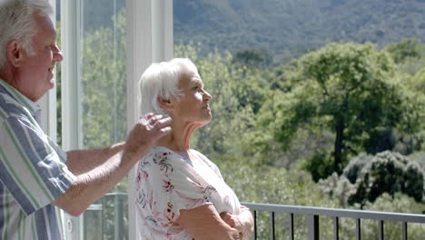 happy senior caucasian couple standing on balcony and embracing, slow motion