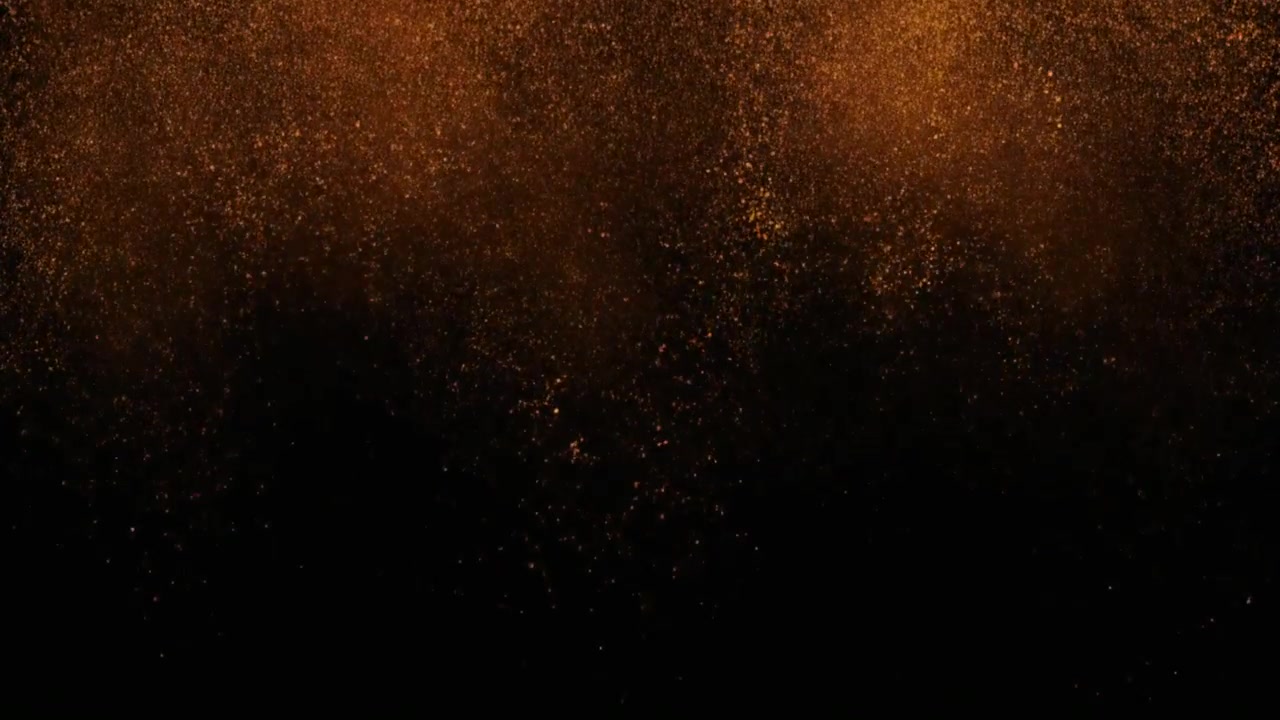 Particelle di polvere dorata che cadono su uno sfondo nero