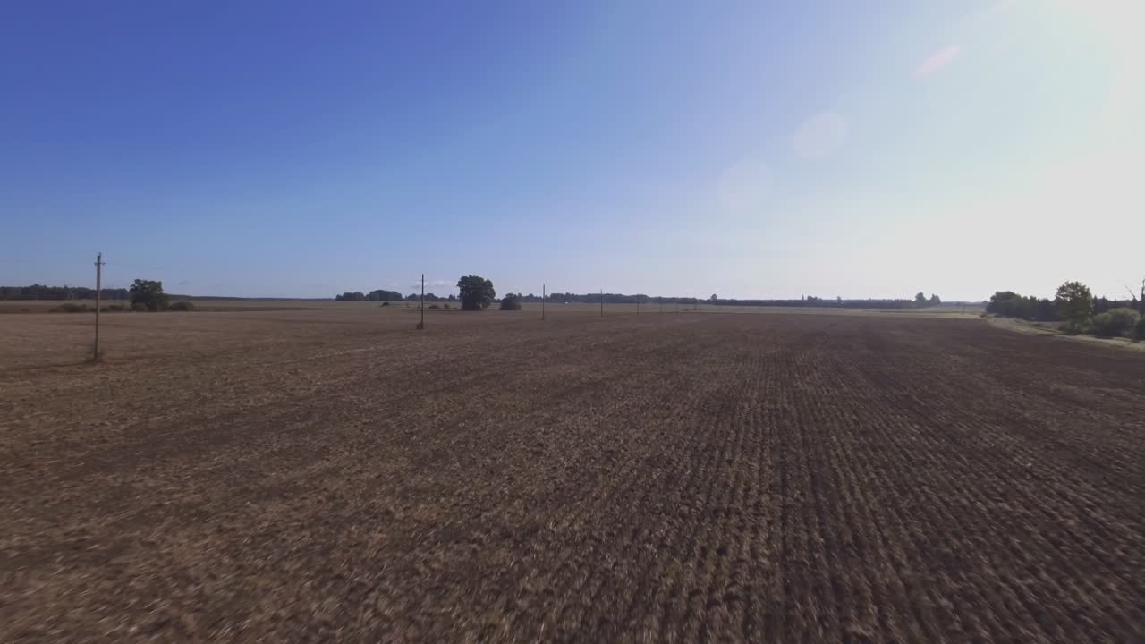 Stromleitungen auf Masten in abgeernteten landwirtschaftlichen Feldern-1