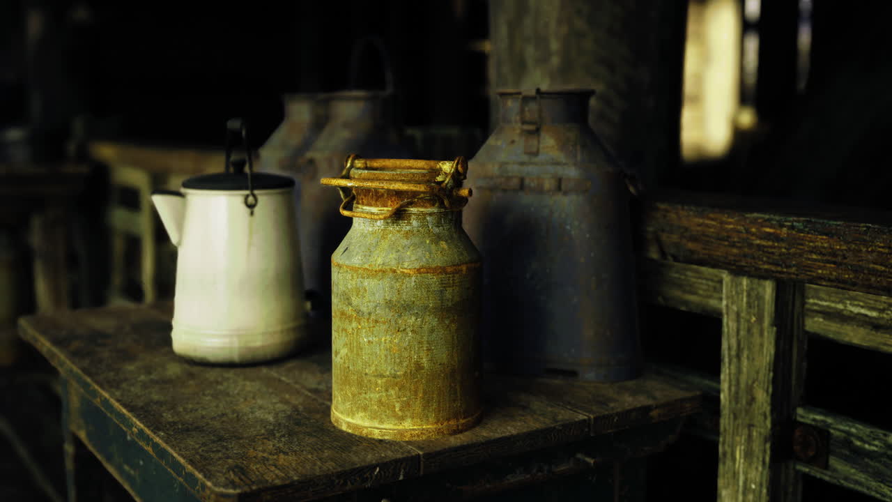 Vintage milk cans on rustic wooden table in a dimly lit barn
