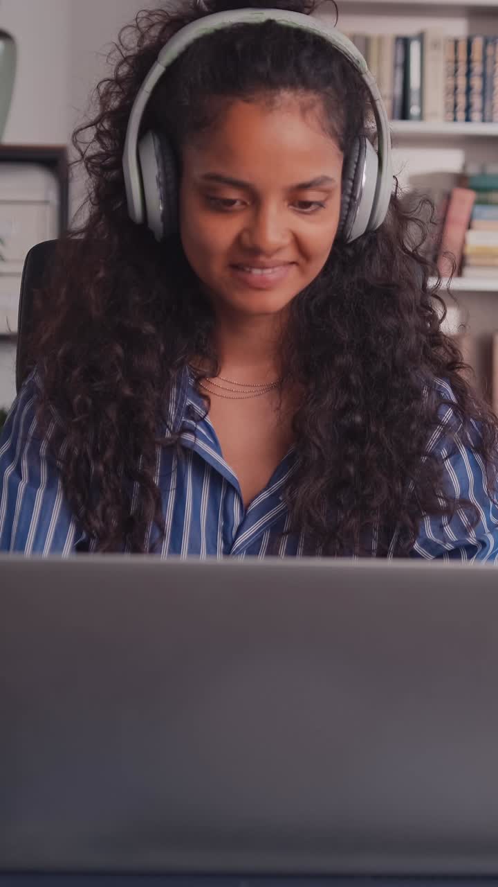 Young woman focused on work while using a laptop at home office