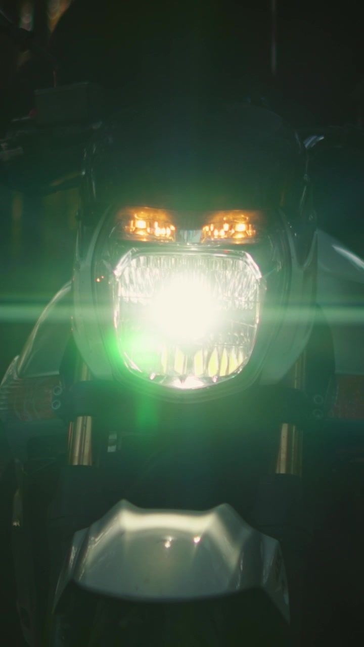 Close-up of Motorcycle Headlight Shining in the Dark