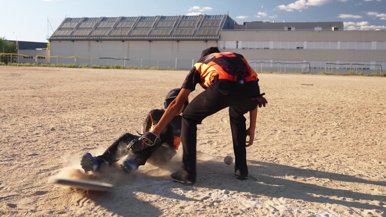 Giovane giocatore di baseball che scivola verso casa base durante una partita