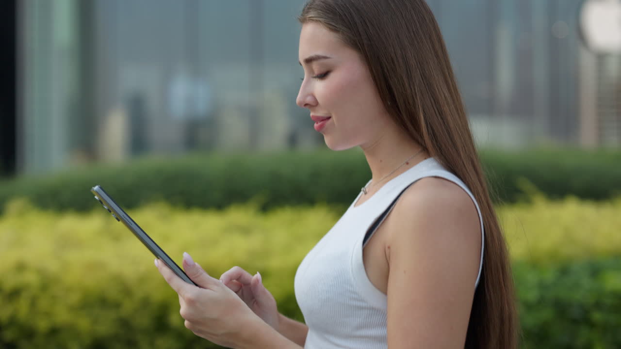 야외에서 태블릿을 사용하는 여성