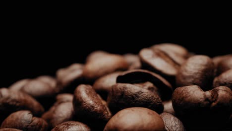 close up shot moving around heap of coffee beans with black background