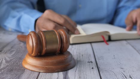 judge reading a law book with gavel on the desk