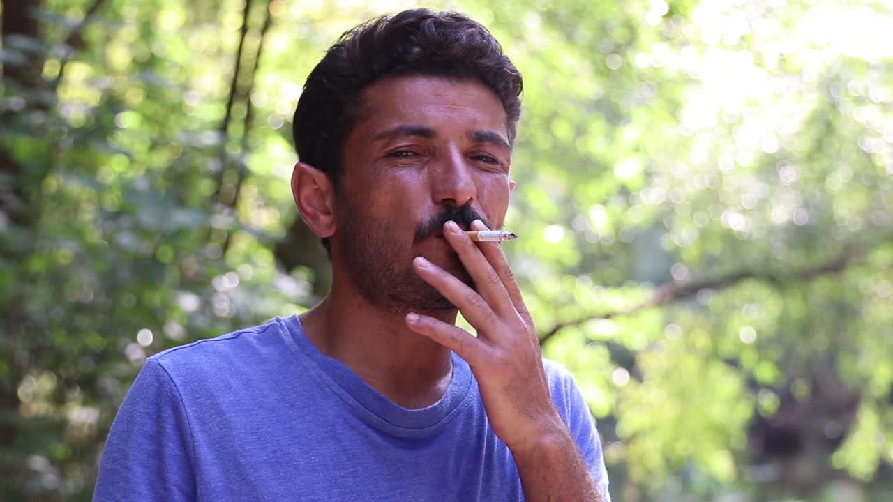 hombre fumando un cigarrillo en el bosque
