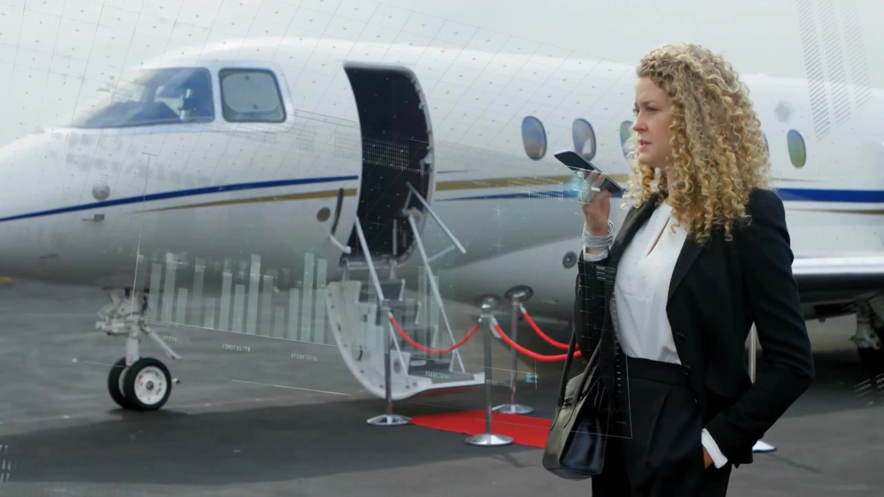 Donna che parla al suo smartphone vicino a un jet privato e attiva grafici olografici con dati di volo