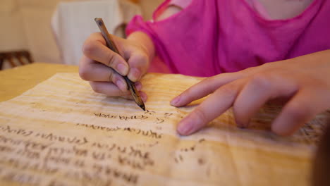 a smooth handheld push-in shot focuses on a scribe's hands writing on a manuscript with a quill pen. the camera gets closer, showing the detail of the ancient calligraphy