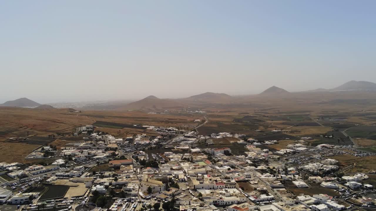 ciudad de niebla del desierto en lanzarote con paisaje de montaña en el fondo, vista aérea