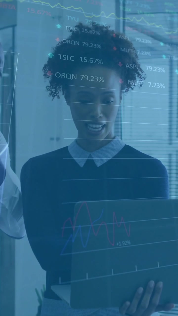 Analyzing financial data on laptop, business people with stock market animation over