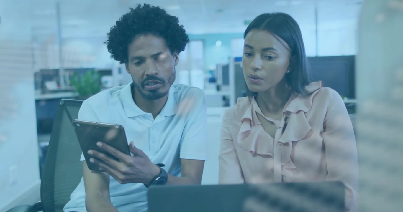 Colleagues picking tablet, swiping code, leaning over laptop studying overlay for tech debugging