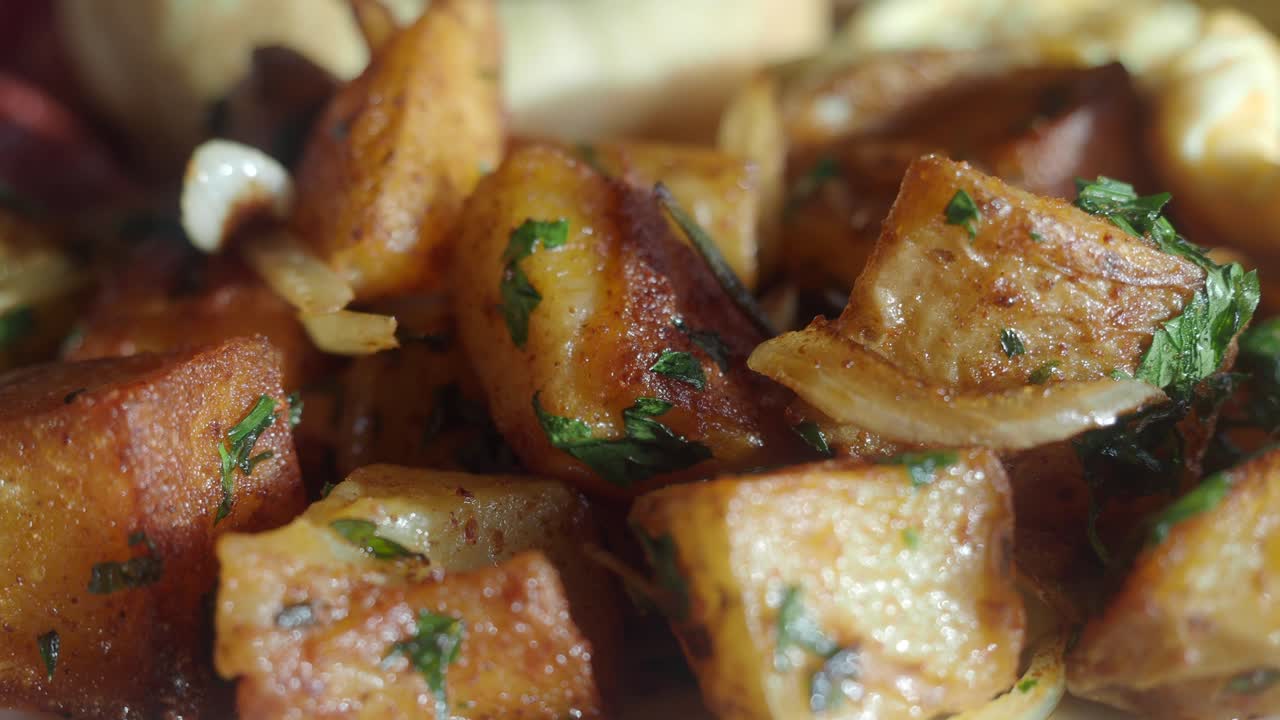 Primo piano di patate arrosto dorate con erbe aromatiche