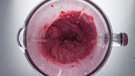 Leckerer-Smoothie-Aus-Roten-Beeren-Im-Mixer-Mischen,-Nahaufnahme,-Draufsicht.-Süßer-Milchshake