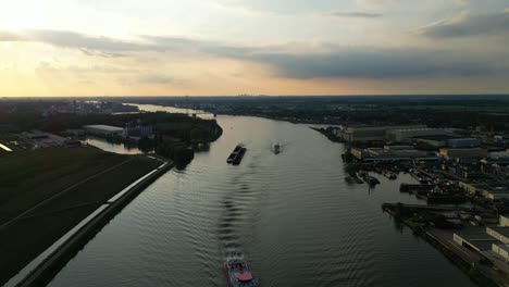 Aerial-View-Over-Beneden-Merwede-During-Sunset-With-Silhouette-Of-Barge-Travelling-Along