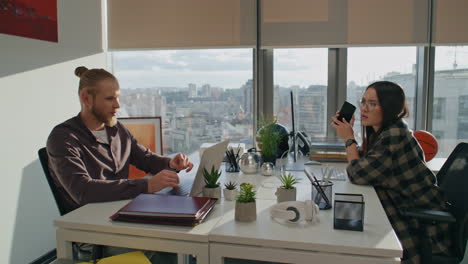 Serious-partners-advising-at-workplace-closeup.-Focused-man-talking-to-woman